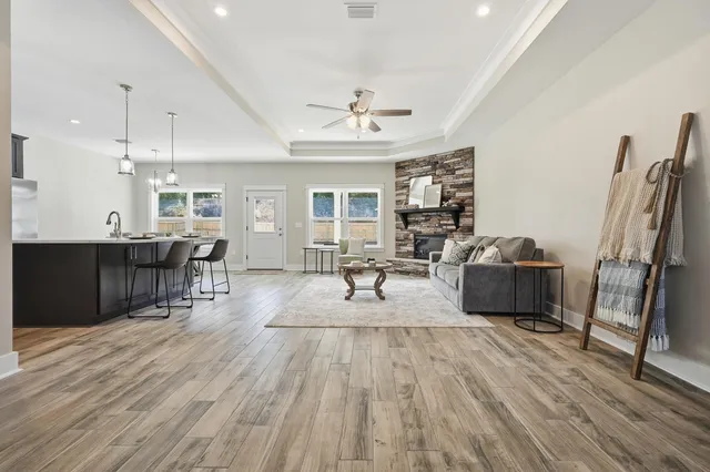 a living room with furniture a large window and wooden floor