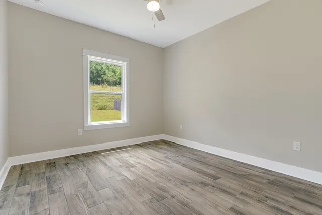 an empty room with a window and wooden floor