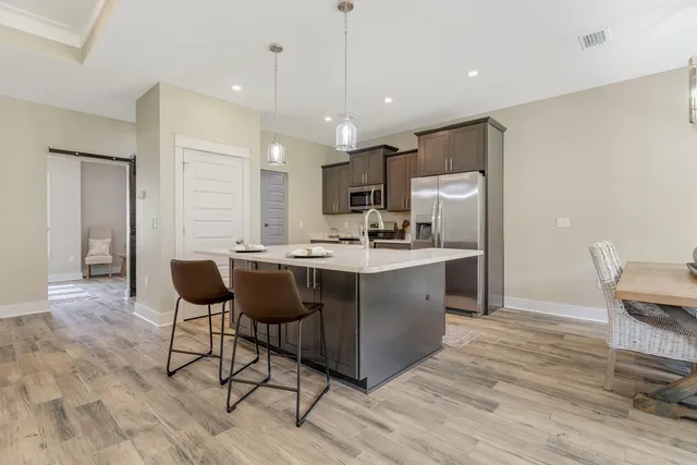 a kitchen with sink refrigerator dining table and chairs