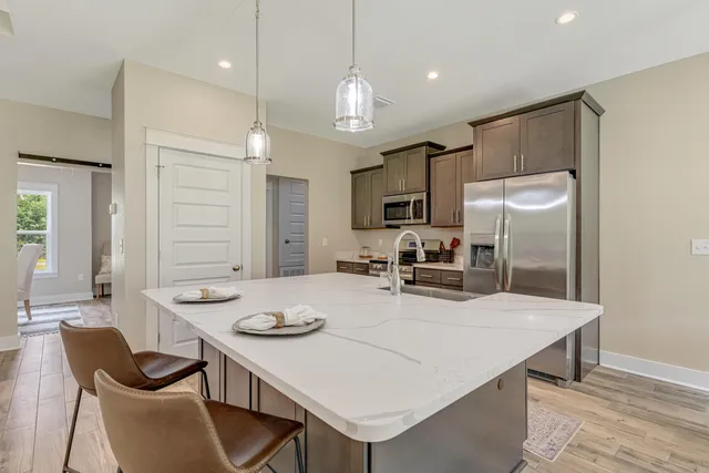 a kitchen with kitchen island a sink stove and wooden floor