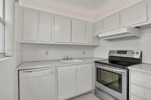an empty room with chandelier fan and windows