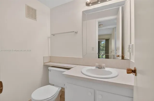 a bathroom with a toilet a sink and mirror