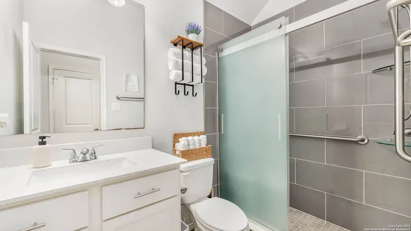 a bedroom with a bed and a flat tv screen on the dresser