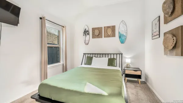 a bedroom with furniture and a large window