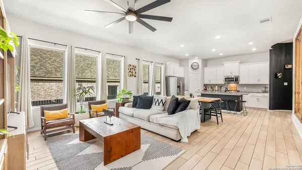 a kitchen with stainless steel appliances granite countertop a stove a sink dishwasher and white cabinets with wooden floor