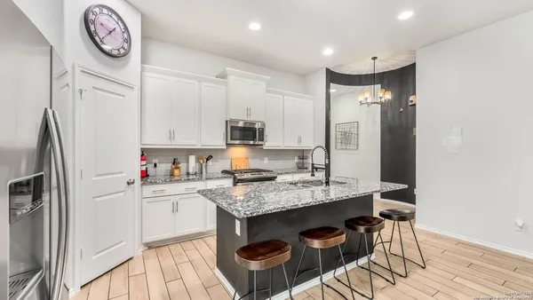 a kitchen with a table chairs refrigerator and cabinets