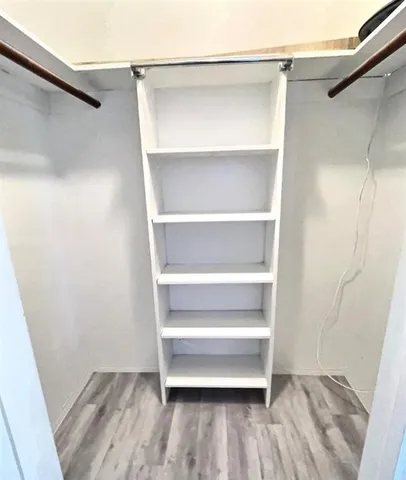 a view of walk in closet with empty racks