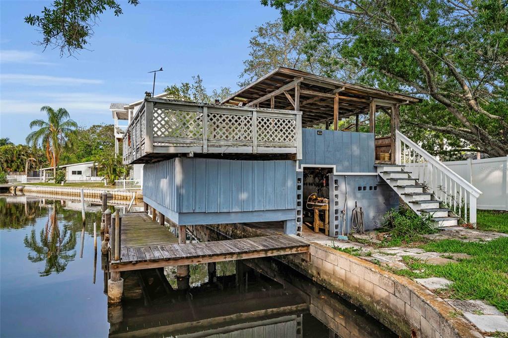 394 Georgia Avenue Crystal Beach, FL 34683 - Photo 21 of 69 a view of a roof deck with table and chairs a barbeque with wooden fence