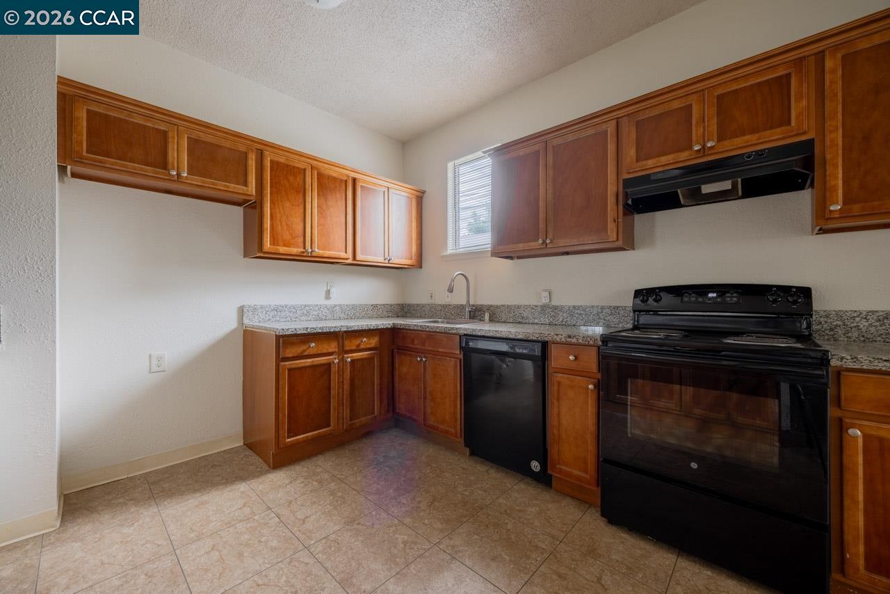 6118 Rutland Drive Carmichael, CA 95608 - Photo 5 of 19 a kitchen with granite countertop a stove top oven microwave and cabinets