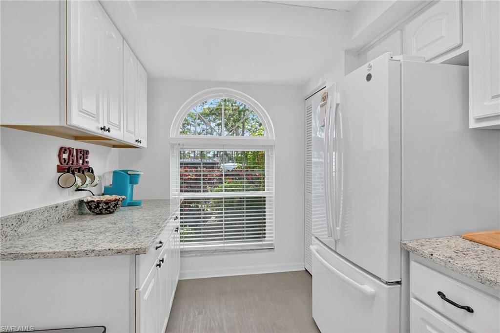 705 Augusta Boulevard, Unit 7054 Naples, FL 34113 - Photo 12 of 28 a kitchen with granite countertop a stove and a white refrigerator