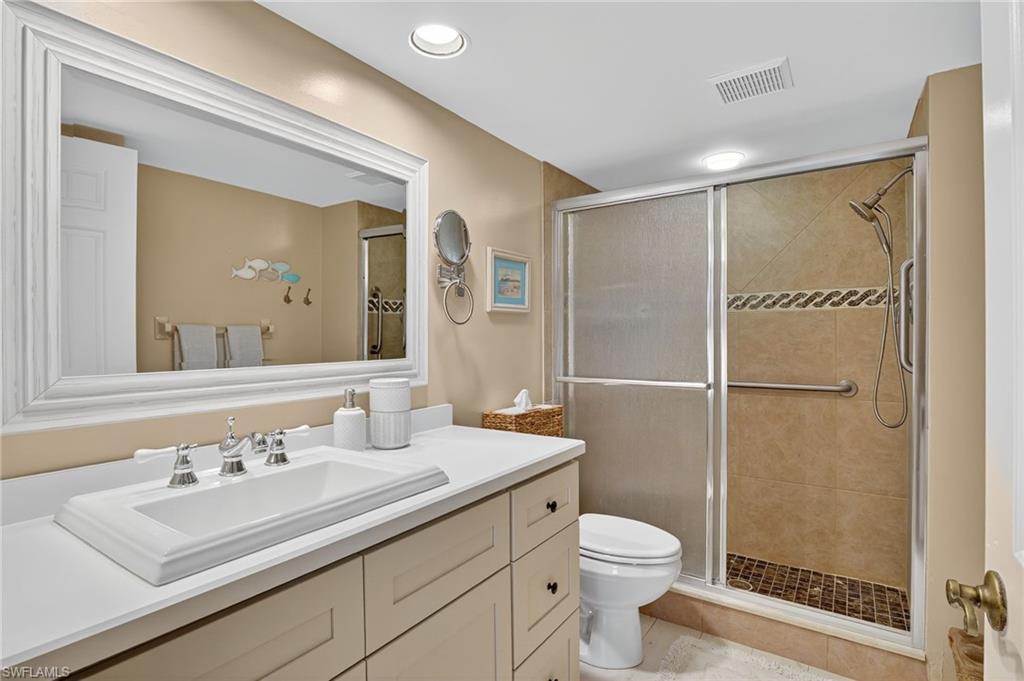 705 Augusta Boulevard, Unit 7054 Naples, FL 34113 - Photo 17 of 28 a bathroom with a sink toilet and shower