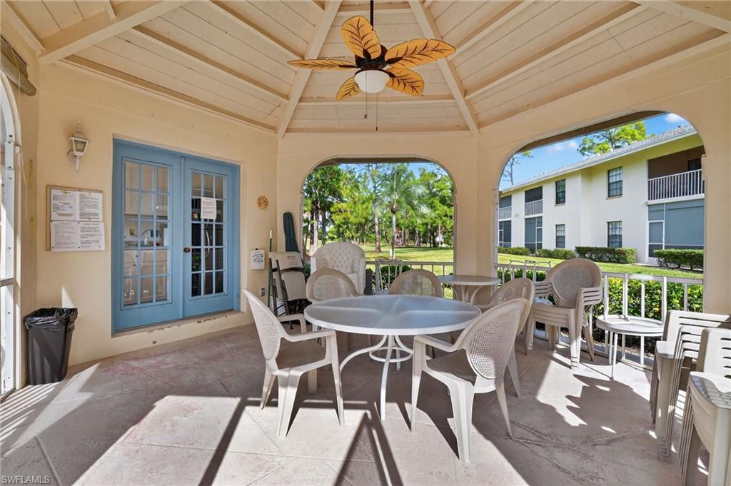 705 Augusta Boulevard, Unit 7054 Naples, FL 34113 - Photo 27 of 28 a dining room with furniture a chandelier and wooden floor
