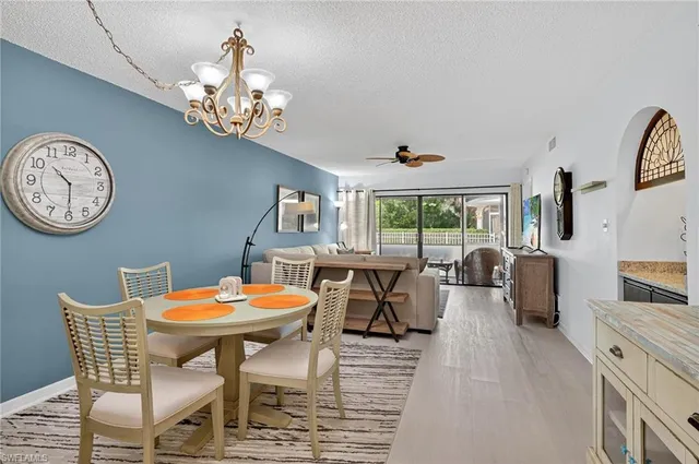 a view of a dining room with furniture a chandelier and wooden floor