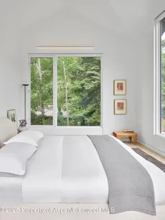 a bed sitting in a bedroom next to a window