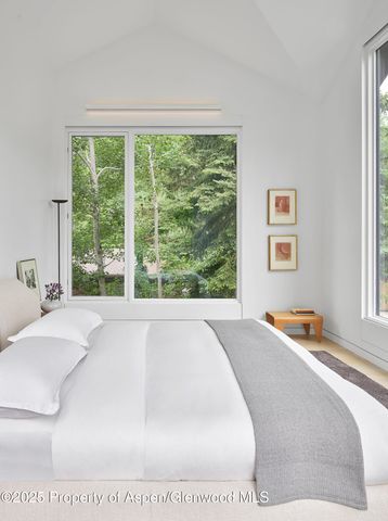 a bed sitting in a bedroom next to a window