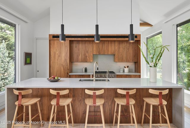 a kitchen with granite countertop a sink a counter top space and cabinets