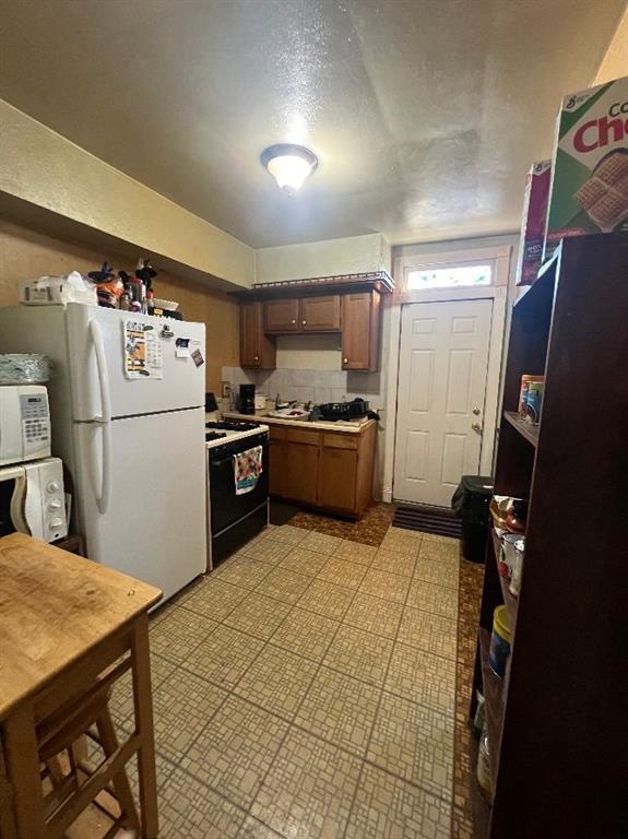 1619 Brownsville Road Pittsburgh, PA 15210 - Photo 15 of 33 a kitchen with granite countertop a refrigerator and a stove top oven