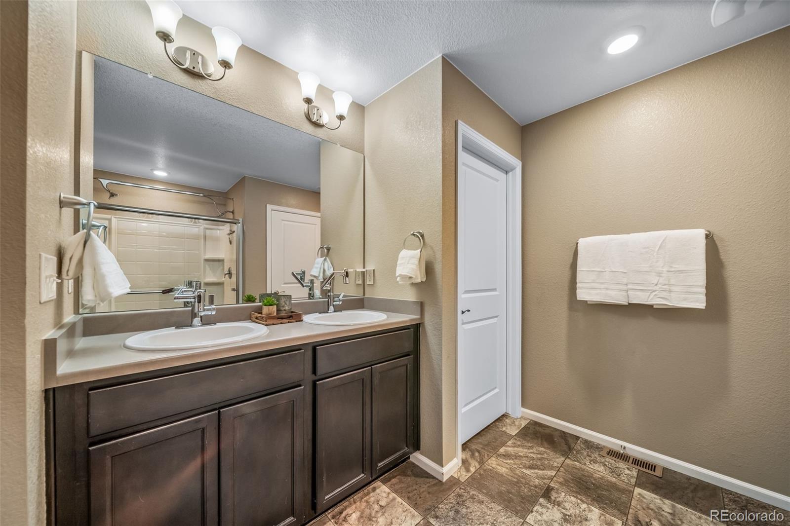 1 South Quantock Street Aurora, CO 80018 - Photo 15 of 43 a bathroom with a sink and a mirror