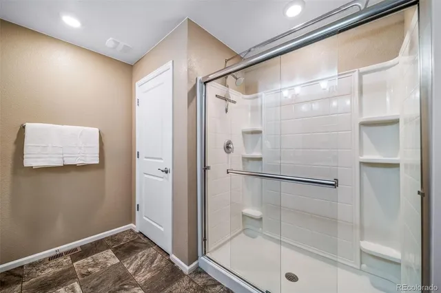 a bathroom with a shower and a glass door