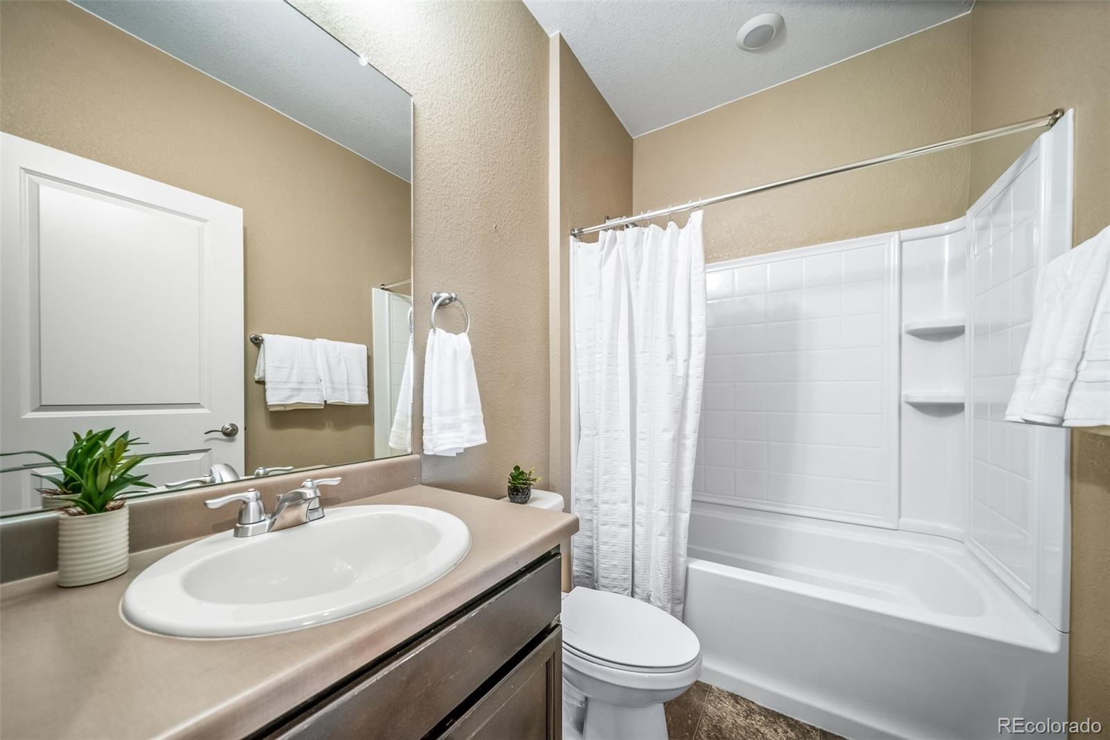 1 South Quantock Street Aurora, CO 80018 - Photo 20 of 43 a bathroom with a sink toilet and shower