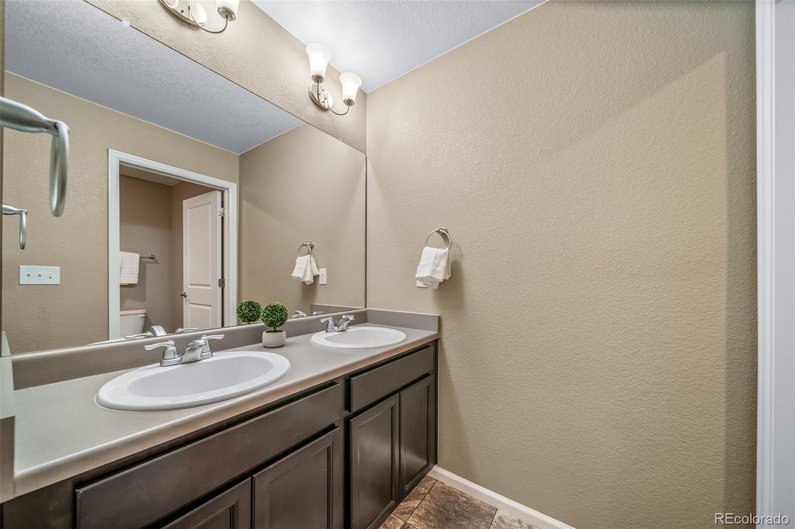1 South Quantock Street Aurora, CO 80018 - Photo 24 of 43 a bathroom with a sink and a mirror