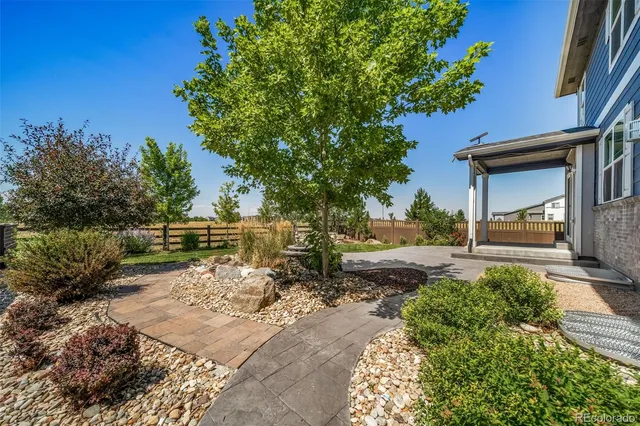 a backyard of a house with a garden and outdoor seating