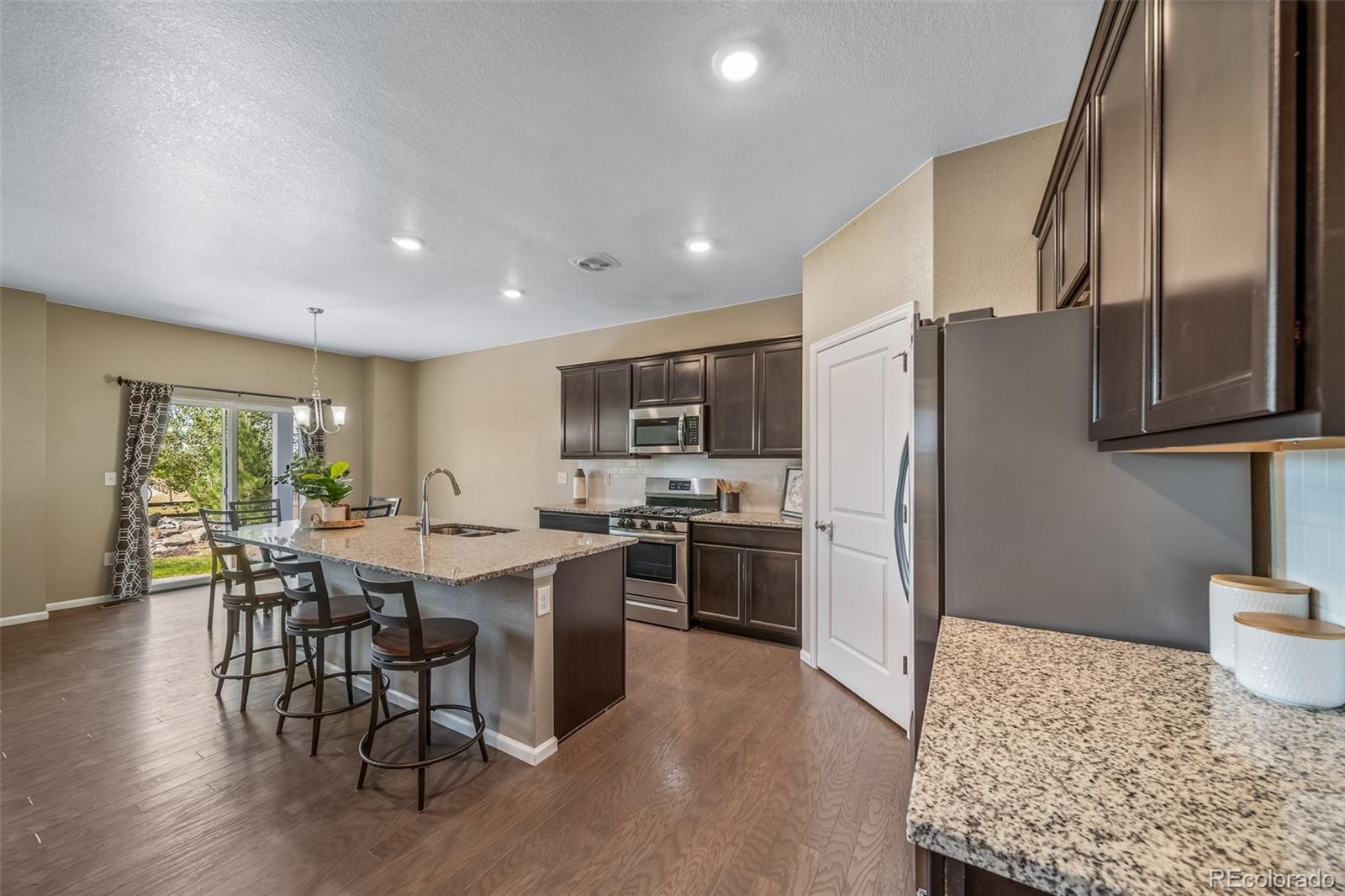 1 South Quantock Street Aurora, CO 80018 - Photo 8 of 43 a open kitchen with stainless steel appliances granite countertop a refrigerator stove microwave and white cabinets