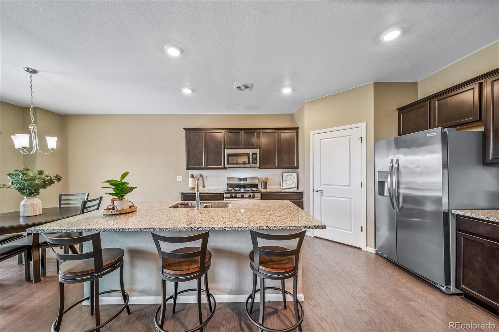 1 South Quantock Street Aurora, CO 80018 - Photo 9 of 43 a kitchen with a table and chairs in it