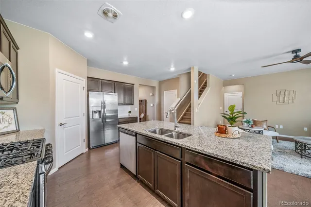 a kitchen with stainless steel appliances granite countertop a sink stove and refrigerator