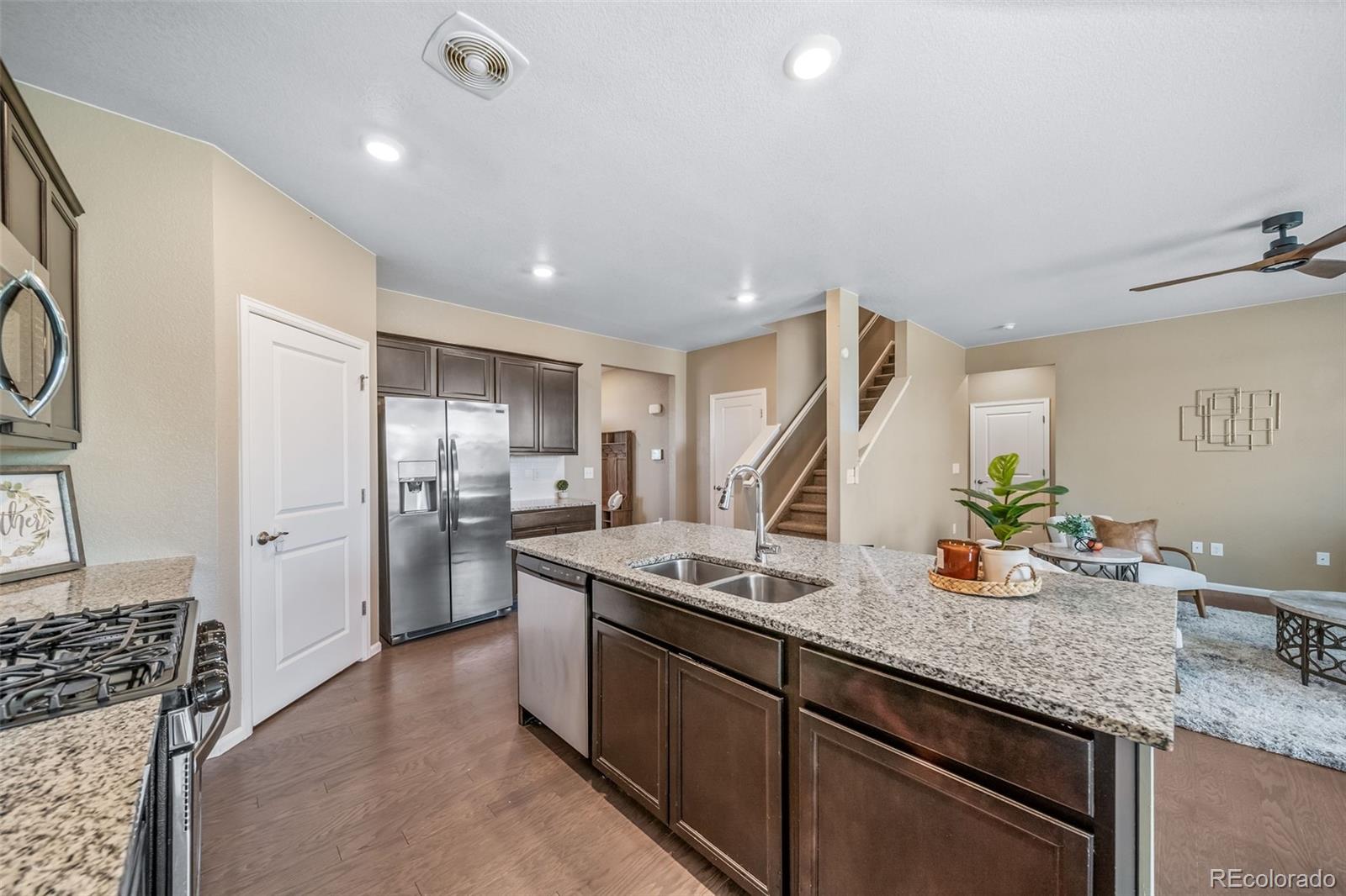 1 South Quantock Street Aurora, CO 80018 - Photo 10 of 43 a kitchen with stainless steel appliances granite countertop a sink stove and refrigerator