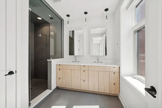 a spacious bathroom with a double vanity sink a mirror and a bathtub
