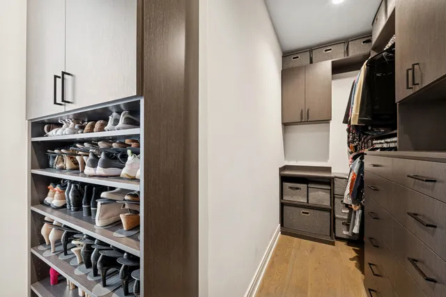 a view of walk in closet with clothes and shoes