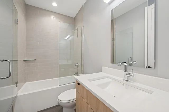 a bathroom with a sink a toilet and a large mirror