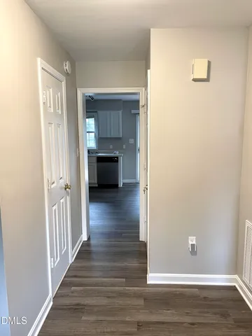 a view of a livingroom with wooden floor and staircase