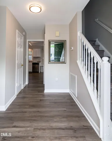 a view of a hallway with wooden floor and staircase