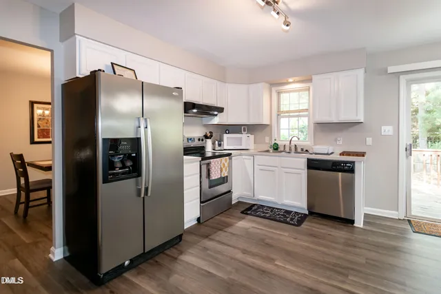 a kitchen with a refrigerator sink and wooden floor