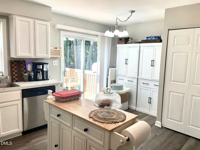 a kitchen with white cabinets and refrigerator