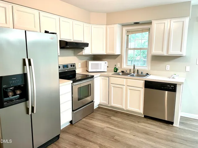 a kitchen with a refrigerator sink and cabinets