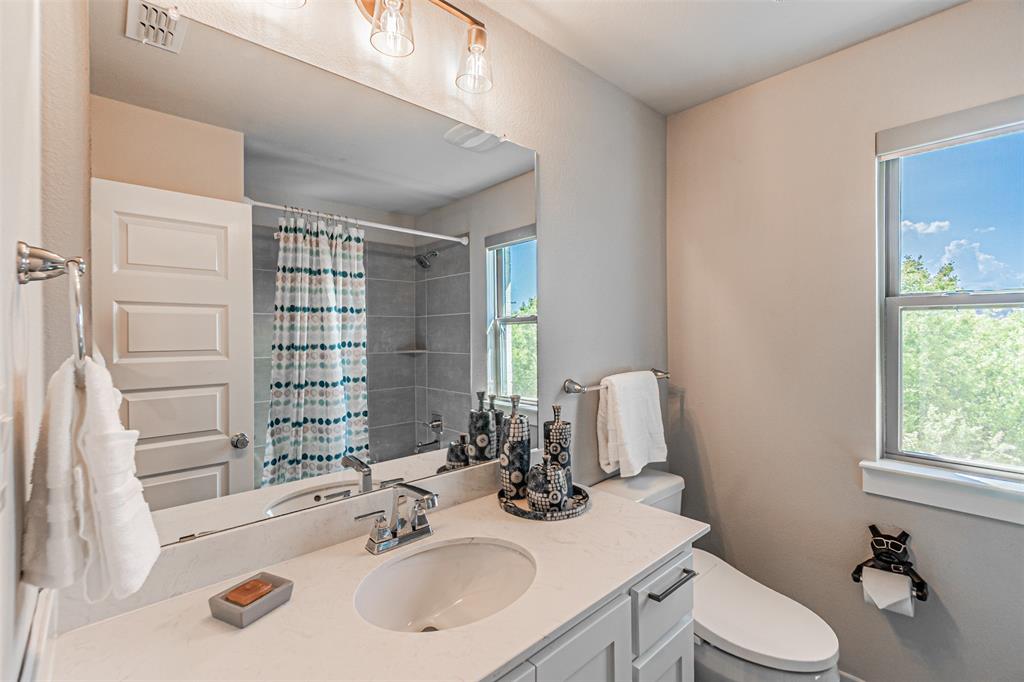 1070 Adair Road Prosper, TX 75078 - Photo 28 of 40 Bathroom featuring a vanity with an integrated sink and light-toned countertop, a large mirror, and a window providing natural illumination