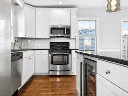 a kitchen with white cabinets and appliances