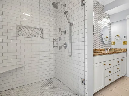 a bathroom with a granite countertop sink a toilet and shower