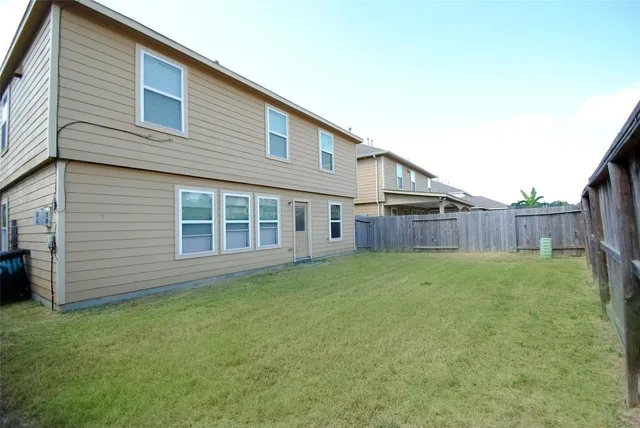 a view of a backyard with plants and wooden fence