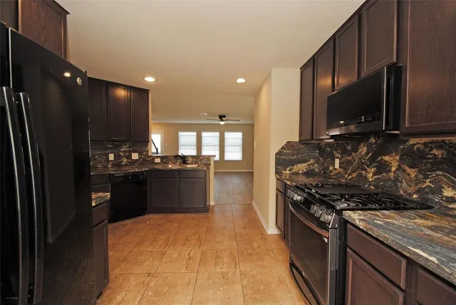 a kitchen with stainless steel appliances granite countertop a stove a sink and a refrigerator