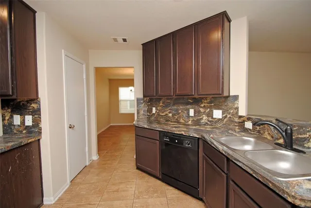 a kitchen with granite countertop a sink and cabinets