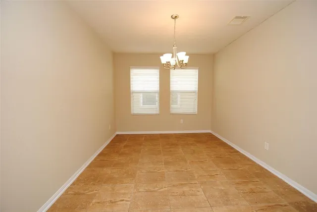 an empty room with windows and chandelier