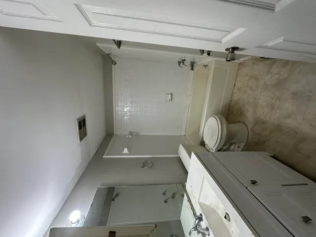 a bathroom with a granite countertop sink a toilet and shower
