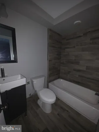 a white toilet sitting next to a bathroom sink and vanity