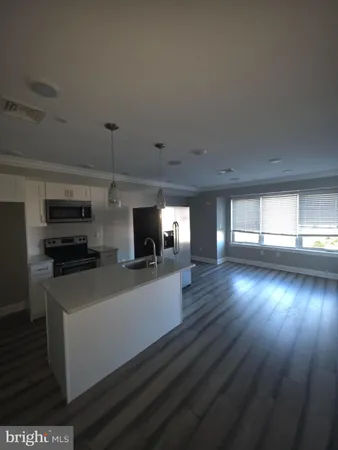 a view of a living room a kitchen with furniture and flat screen tv