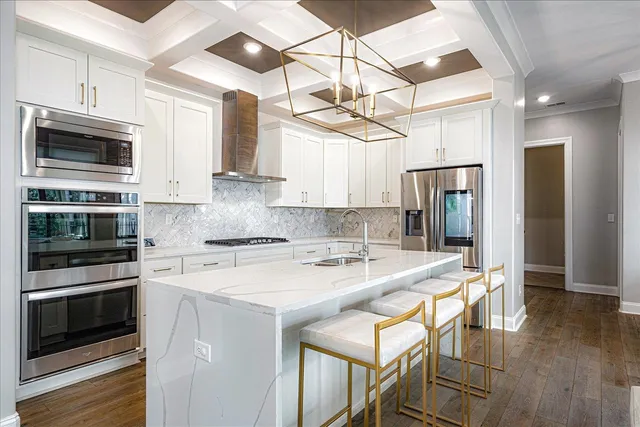 a kitchen with stainless steel appliances granite countertop a stove refrigerator and microwave