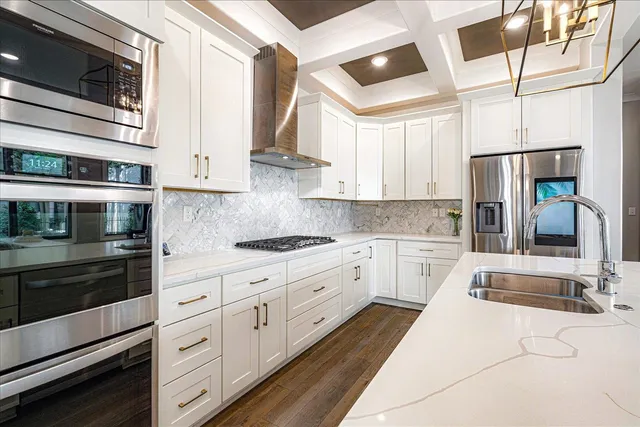 a kitchen with granite countertop white cabinets stainless steel appliances and sink